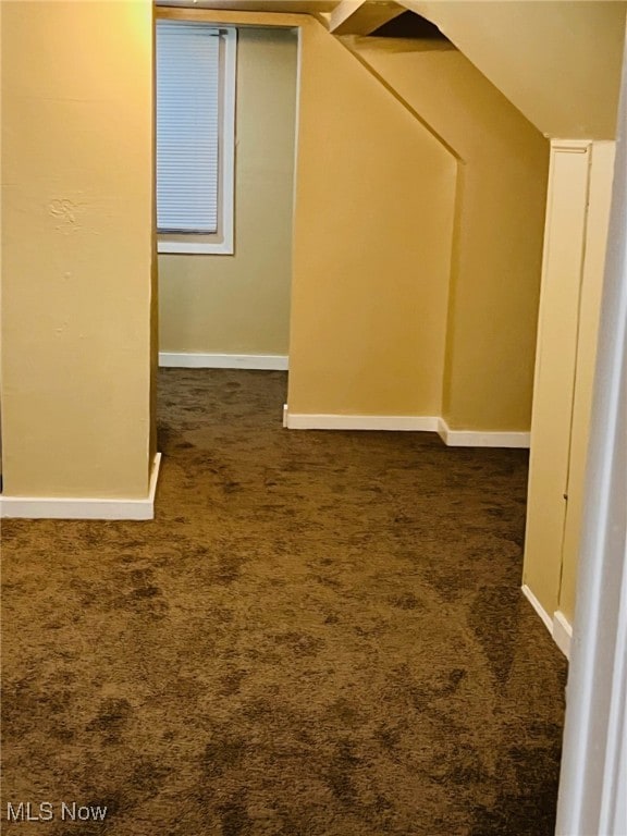 additional living space with dark carpet