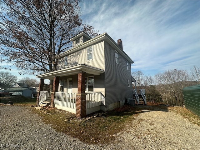 view of front property with a porch and central AC