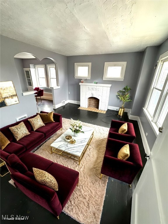 living room featuring a textured ceiling and a fireplace