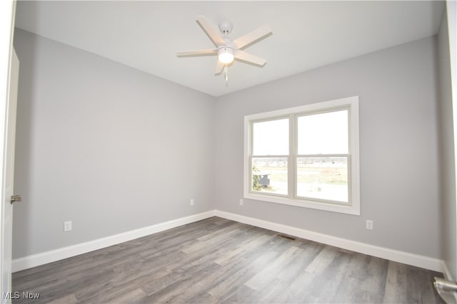 unfurnished room with ceiling fan and dark hardwood / wood-style floors