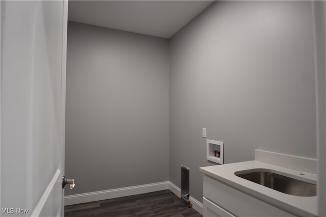 clothes washing area featuring washer hookup, dark hardwood / wood-style floors, cabinets, and sink