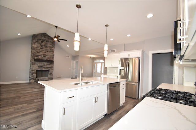 kitchen with sink, dark hardwood / wood-style flooring, vaulted ceiling, white cabinets, and appliances with stainless steel finishes