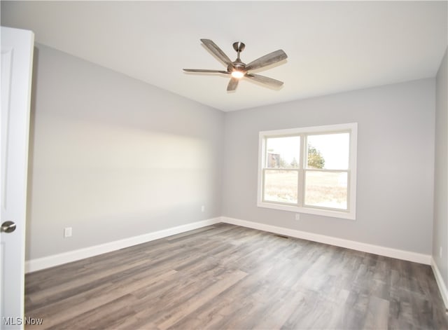 empty room featuring ceiling fan and dark hardwood / wood-style flooring