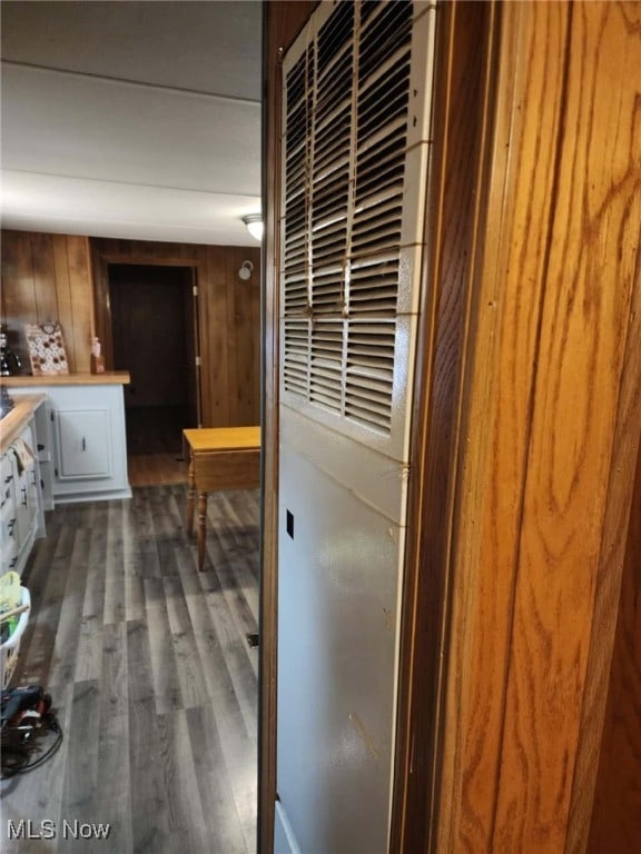 interior space with wooden walls and dark wood-type flooring