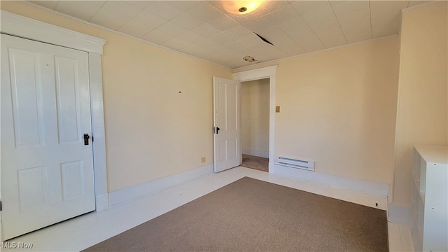 spare room with carpet and a baseboard radiator