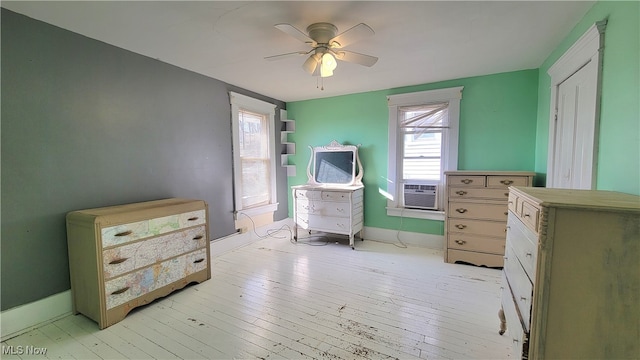 bedroom featuring ceiling fan, light hardwood / wood-style floors, and cooling unit