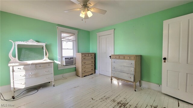 bedroom with ceiling fan, cooling unit, and light wood-type flooring