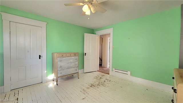 unfurnished bedroom featuring light hardwood / wood-style flooring, baseboard heating, and ceiling fan