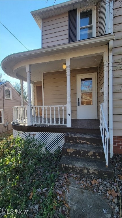 view of exterior entry with covered porch