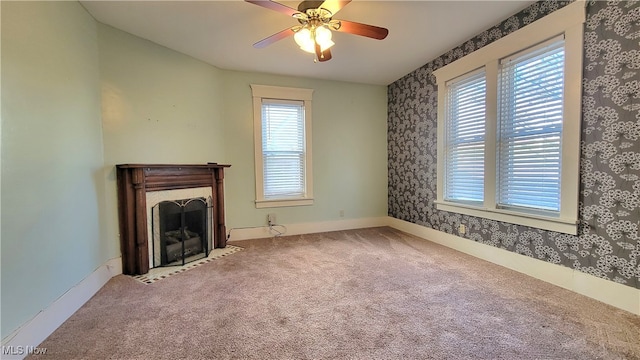 unfurnished living room featuring carpet floors, plenty of natural light, and ceiling fan