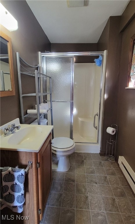 bathroom featuring vanity, a shower with door, toilet, and baseboard heating