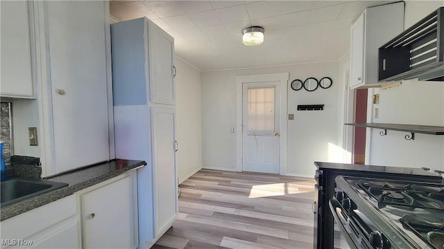 119 Euclid Pl, Marietta, OH 45750 - kitchen featuring dark countertops, gas range, light wood-style flooring, white cabinets, and ornamental molding