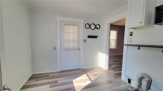 interior space featuring ornamental molding and light wood-type flooring