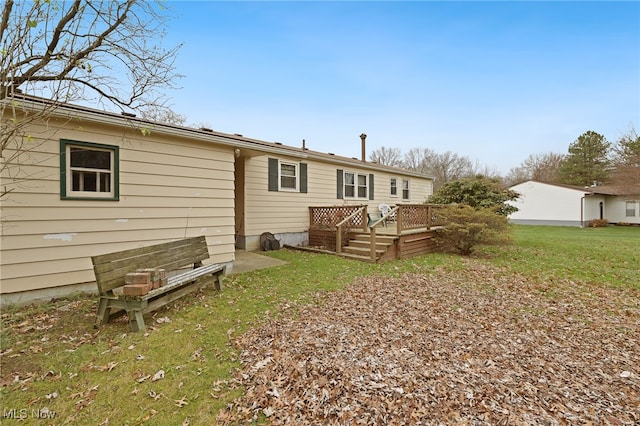 back of property featuring a lawn and a wooden deck