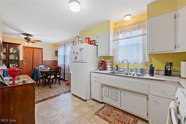 kitchen featuring white cabinetry, sink, ceiling fan, stove, and white fridge