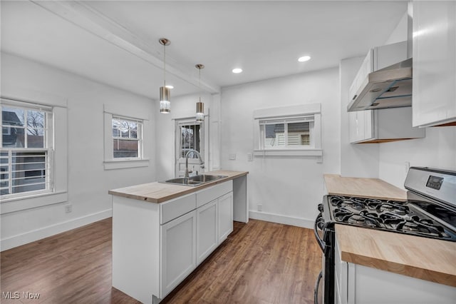 kitchen with black range with gas stovetop, sink, white cabinetry, hanging light fixtures, and butcher block counters