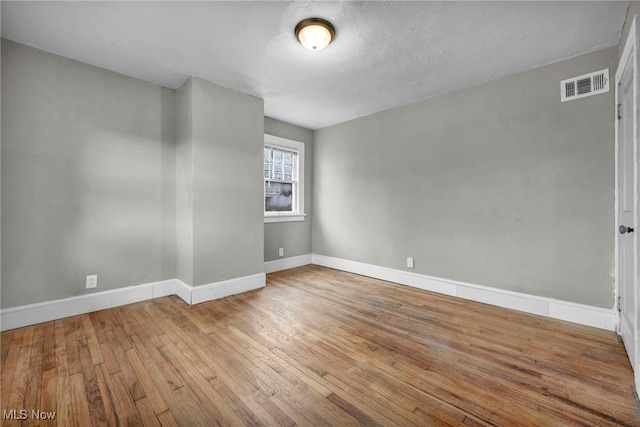 unfurnished room with wood-type flooring