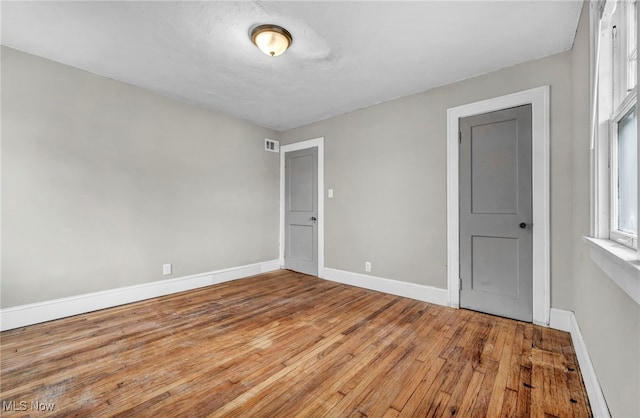 empty room with hardwood / wood-style flooring