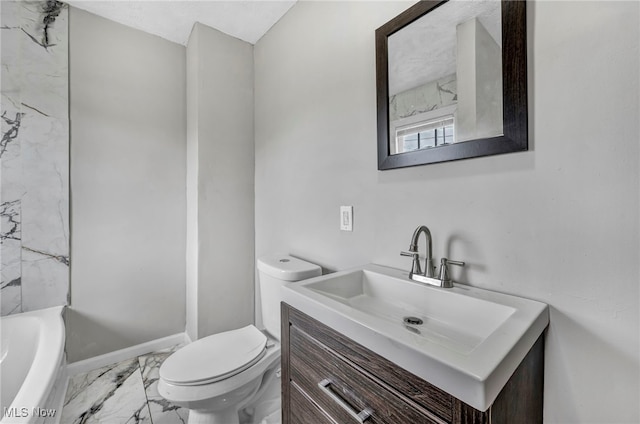 bathroom featuring vanity, toilet, and a washtub