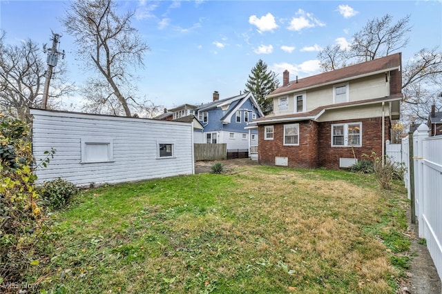 rear view of property featuring a lawn