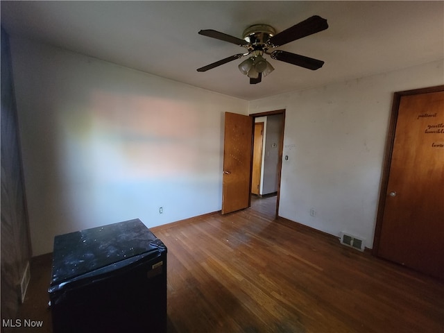 spare room with dark hardwood / wood-style floors and ceiling fan