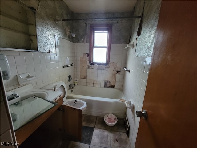 full bathroom with tiled shower / bath combo, toilet, tile walls, and vanity