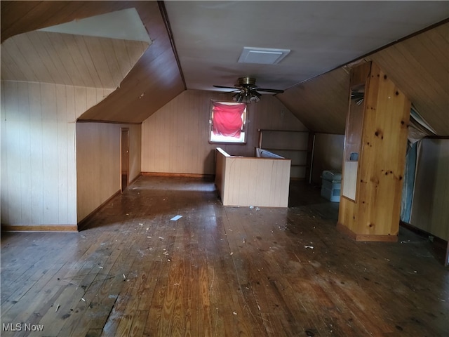 additional living space featuring lofted ceiling, dark hardwood / wood-style floors, and wooden walls