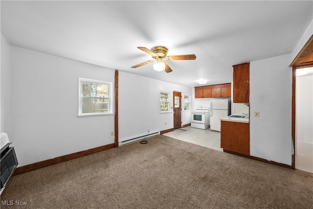 unfurnished living room with heating unit, light colored carpet, baseboard heating, and ceiling fan