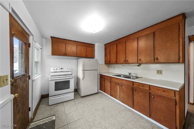 kitchen with decorative backsplash, light tile patterned flooring, white appliances, and sink