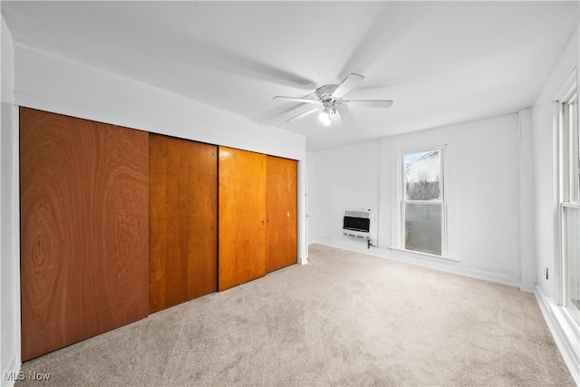 unfurnished living room with ceiling fan, light carpet, and heating unit