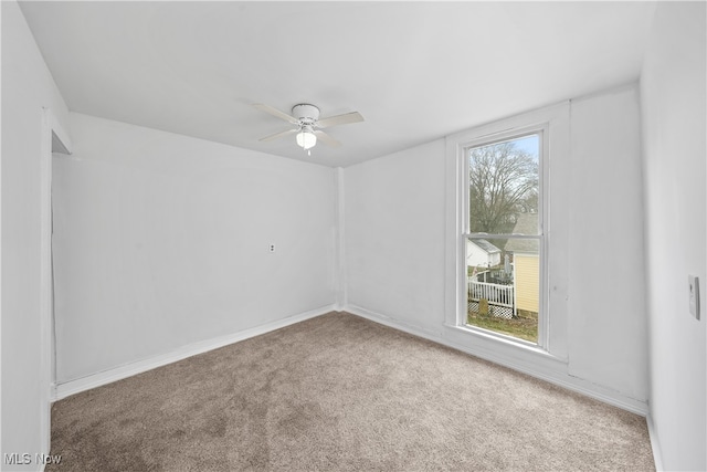 carpeted spare room with ceiling fan