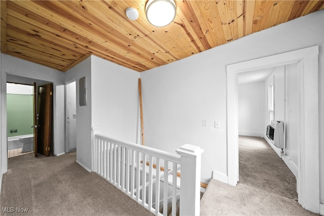 hall featuring carpet floors, heating unit, and wooden ceiling