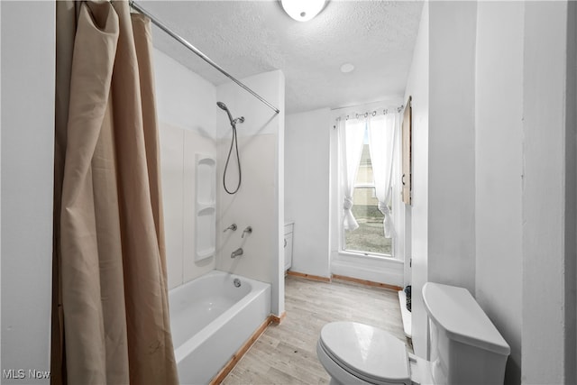 bathroom with hardwood / wood-style floors, toilet, shower / bath combo with shower curtain, and a textured ceiling