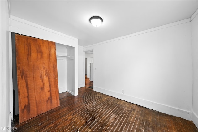 unfurnished bedroom featuring dark hardwood / wood-style floors and a closet