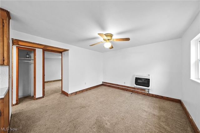 unfurnished bedroom featuring carpet, ceiling fan, and heating unit