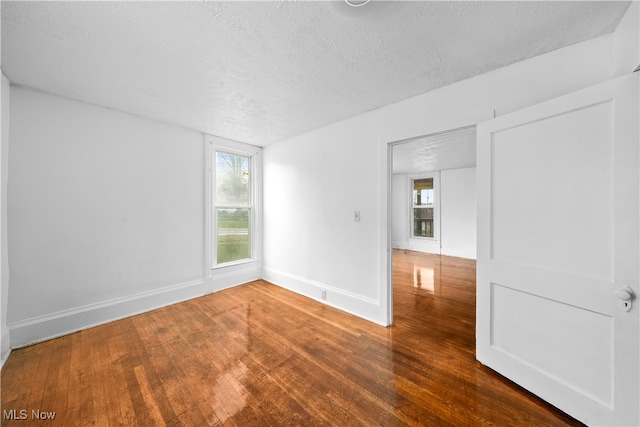 unfurnished room featuring hardwood / wood-style floors and a textured ceiling