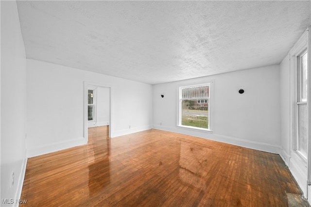 spare room with a textured ceiling and hardwood / wood-style flooring