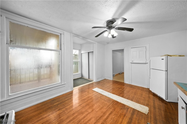 unfurnished room featuring a textured ceiling, dark hardwood / wood-style flooring, and ceiling fan