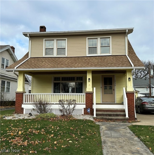 view of front of home with a porch and a front lawn