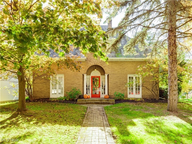 view of front of property with french doors and a front lawn