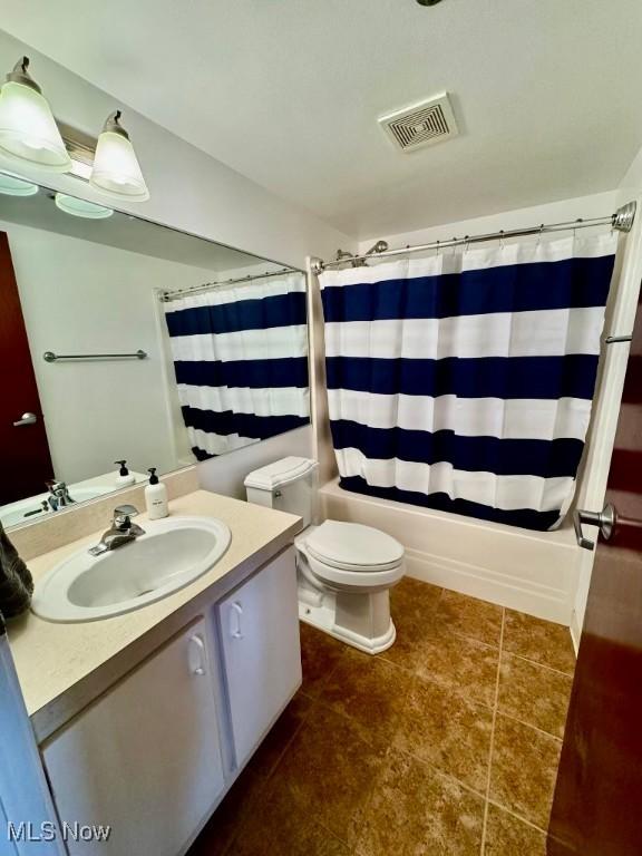 full bathroom with tile patterned floors, vanity, shower / bath combo, and toilet