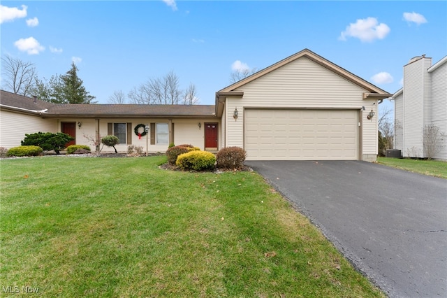 ranch-style house with a garage, central air condition unit, and a front yard