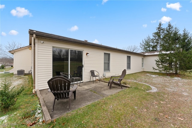 rear view of property featuring central AC unit, a yard, and a patio