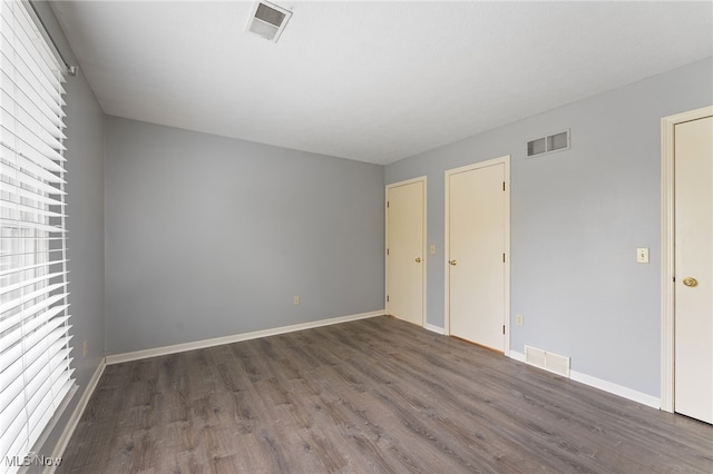 unfurnished room with dark wood-type flooring