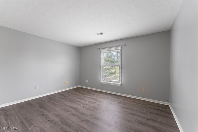 unfurnished room with a textured ceiling and dark wood-type flooring