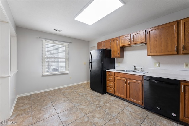 kitchen with light tile patterned floors, sink, and black appliances