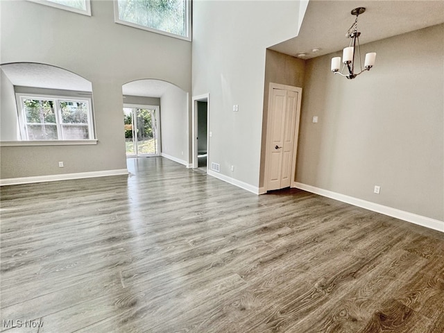 interior space featuring plenty of natural light, a towering ceiling, and hardwood / wood-style floors