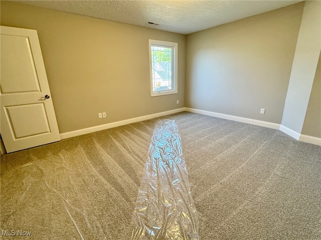 empty room featuring carpet flooring and a textured ceiling