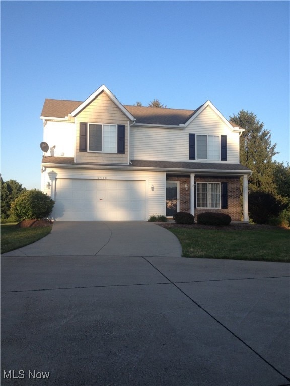 front facade with a garage and a front lawn