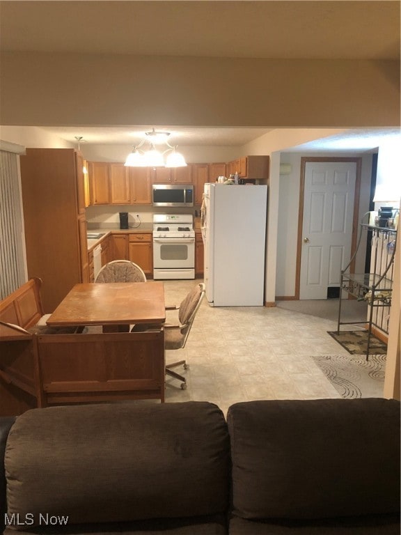 kitchen with white appliances and a notable chandelier